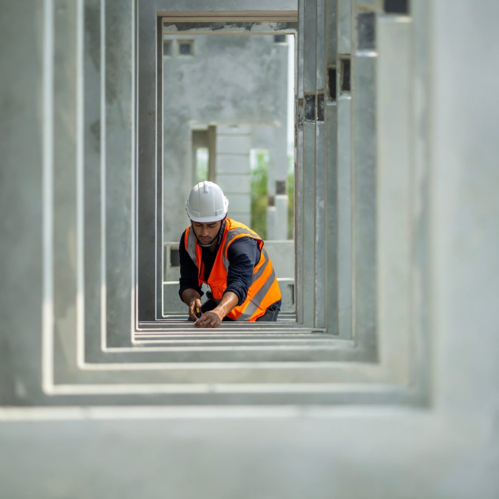 Male engineers are inspecting and controlling the work of the employees and the quality of the manufactured products to meet the standards. In industrial factories producing precast prefabricated walls